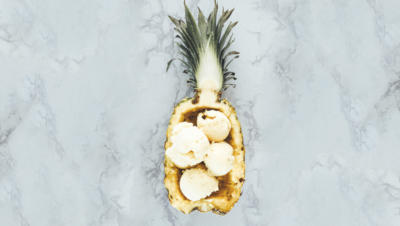 scoops of ice cream in halved pineapple